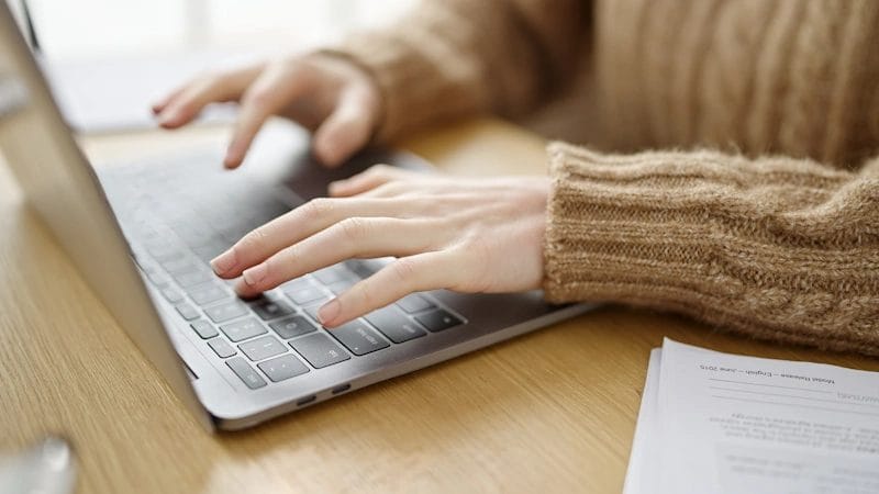 A person typing on a laptop computer